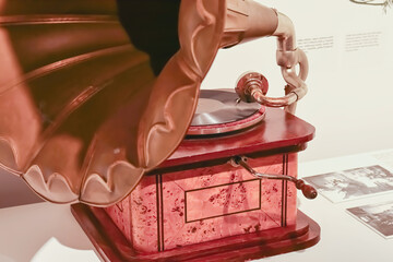 Vintage gramophone of bronze and wood with deep shadows close up view