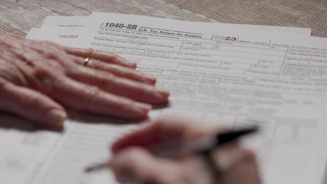 senior woman filling out a 1040-SR tax form