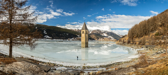 Panorama shot of flooded church tower in Lake Reschen (Reschensee) in South Tyrol, Italy