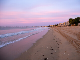 La Baule-Escoublac, France. Amazing view of the sunrise with clouds in the colors of pink and purple. Sea waves along the seashore at sunrise. Morning time. Ocean view