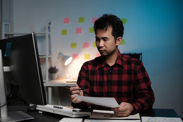 A man is sitting at a desk with a computer monitor