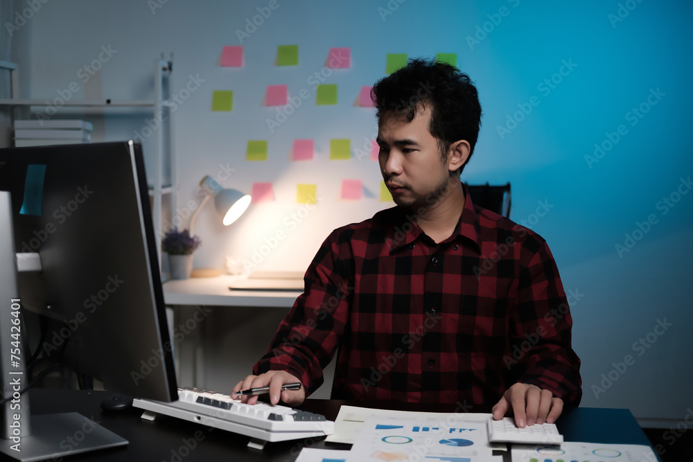 Poster A man is sitting at a desk with a computer monitor and keyboard in front of him