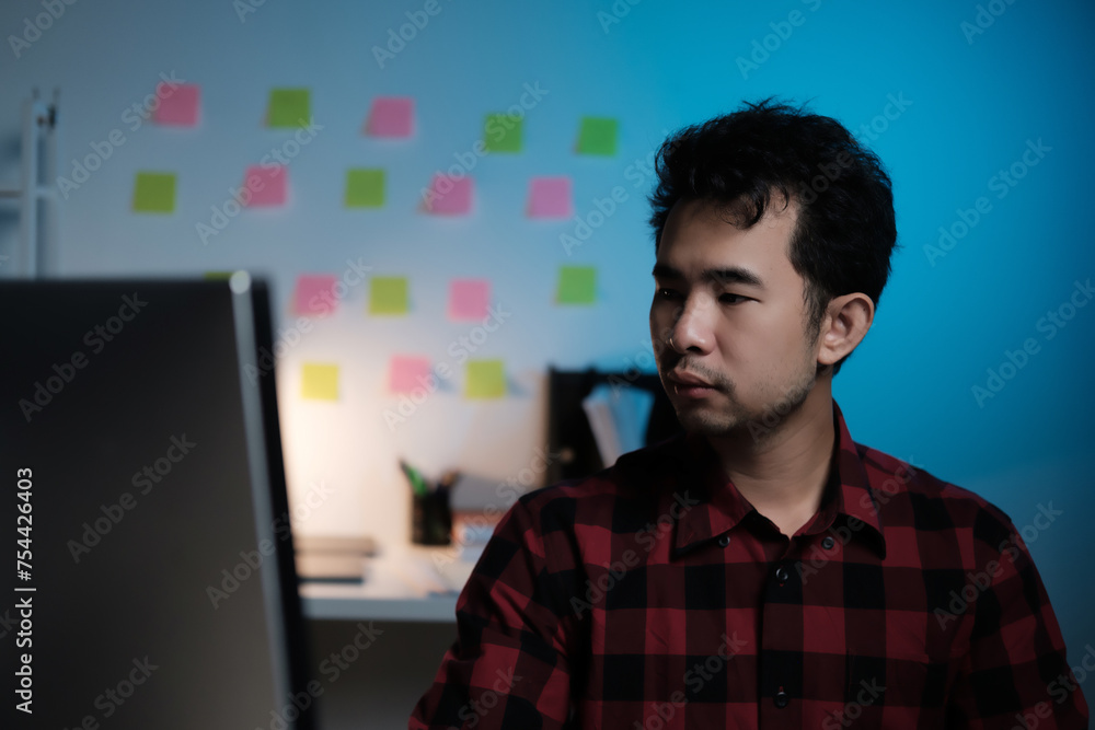 Poster A man is sitting in front of a computer monitor with a green