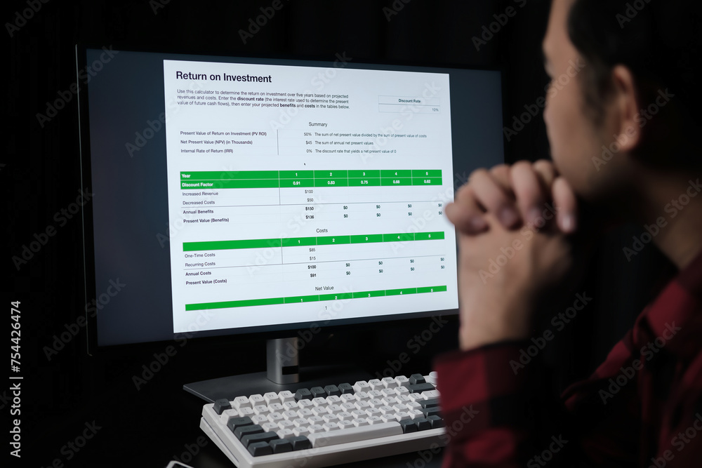 Poster A man is looking at a computer screen with a green sign that says 