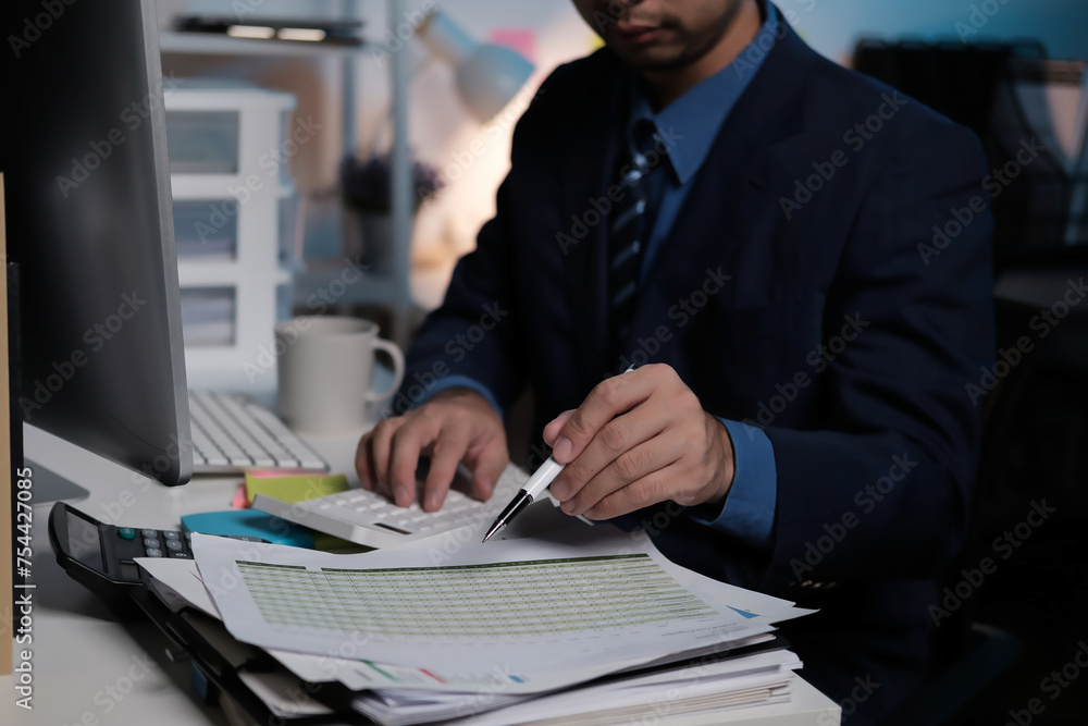 Poster a man in a suit is typing on a keyboard with a pen in his hand