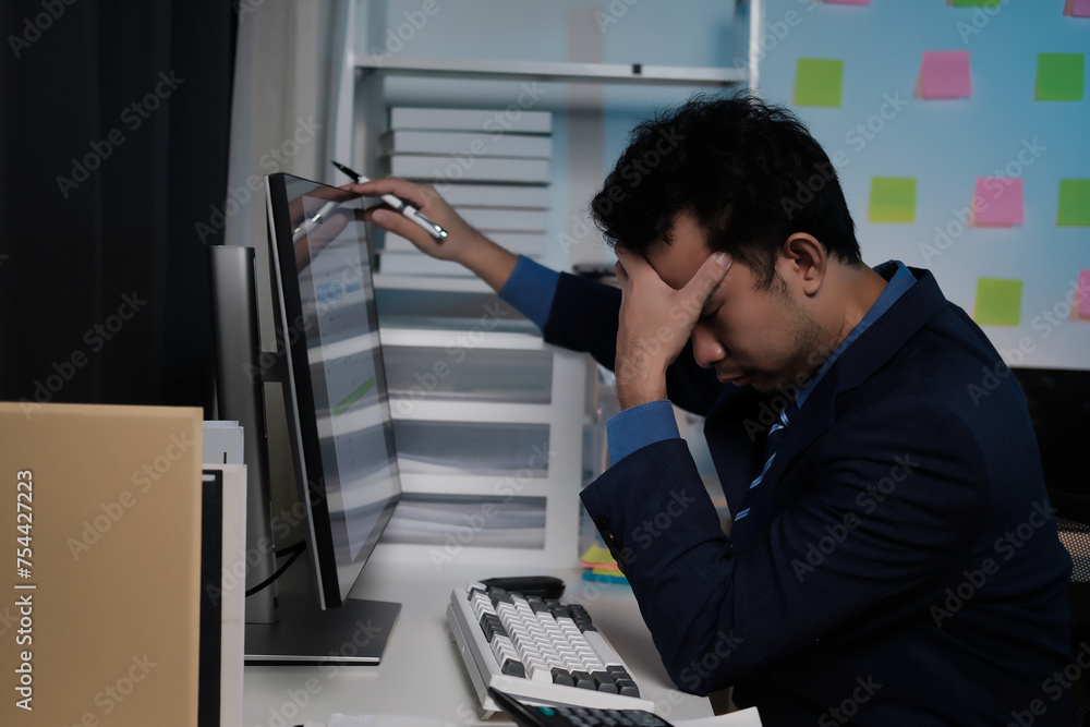 Poster A man is sitting at a desk with a computer monitor in front of him