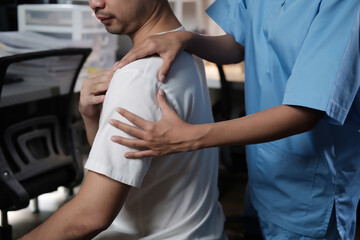 Fototapeta premium A man is being massaged by a woman in a blue shirt