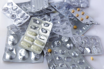 View image of used empty blister packs. Group of heap of prescription drug packages. Half empty half full. White background with copy space. Overuse of drugs or addiction concept idea.