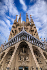 Passion Façade of the Sagrada Família with a cloudy sky in Barcelona, Spain.