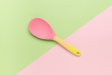 A beautiful silicone spoon on a two-tone background.