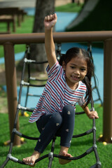 Little girl having fun on the playground in the park. (Selective focus)