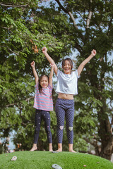 Obraz premium Happy 2 asian chlidren playing together in the park at daytime.