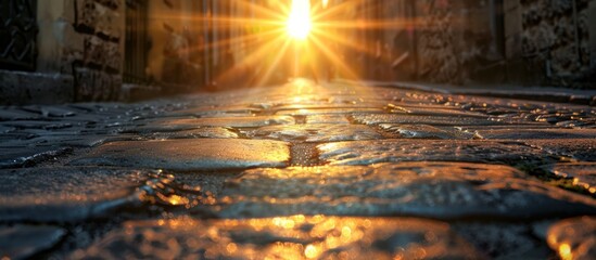 Bright sunlight illuminates the cobblestone street, casting sharp shadows. The contrast between light and dark enhances the texture of the stones. - obrazy, fototapety, plakaty