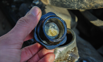 white emulsion on the oil filler cap of a car engine. diagnostics of the engine of an old car. cap...