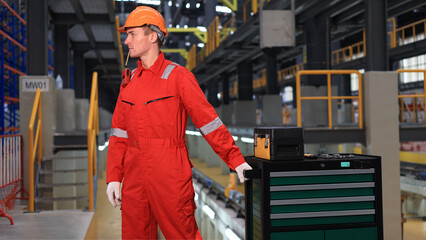 A railway maintenance engineer is seen pulling a toolbox on a cart at the electrical train factory.