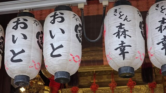 Japanese lanterns hanging at a shrine in sunny Kyoto, Japan