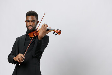 Elegant African American Man Playing the Violin in Tuxedo on White Background