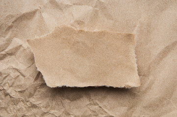 Kraft paper  piece with ripped edge on brown paper background