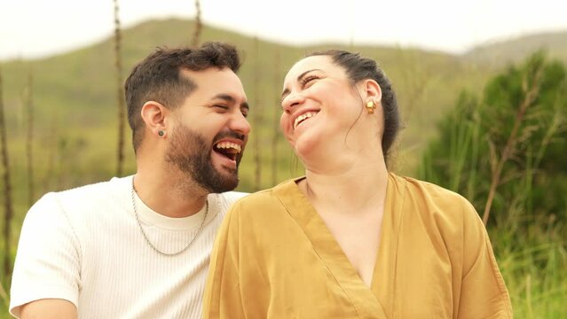 Portrait of a cheerful family having fun outdoors. A happy couple close up face laughing outside. Cheerful man and woman spending summer honeymoon together in the mountains. The concept of joy happine