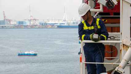 Seaman crew member of cargo vessel  equipped with personal protective equipment operate life boat...