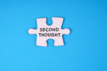 Motivational and inspirational word. SECOND THOUGHT written on a piece of jigsaw puzzle. On blue...
