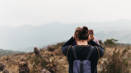 Active traveler photographing the mountainous paramo landscape in Colombia, immersed in nature