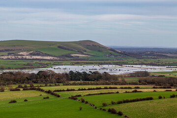 Looking out from Kingston Ridge in Sussex towards Mount Caburn, with flooded fields due to recent heavy rain - 754479634