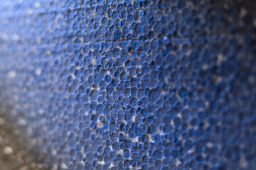 Styrofoam plate, close-up of granules, macro, illuminated by cold light.