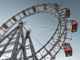 Wiener Riesenrad in Vienna, Austria. Historic tall Ferris wheel with red gondolas at the entrance of the Prater amusement park. 