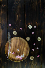 Chocolate easter eggs and dried lavender on a wooden plate with wicker balls on dark wooden background. Copy space. Easter concept.