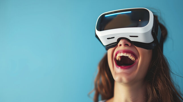 Close-up of a young laughing woman wearing white augmented virtual reality glasses on a studio blue background