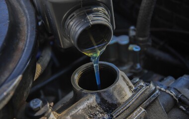 pouring oil into the engine of an old car. blur.