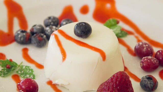 Blueberry is being topped on a Berry Garnished Ice Cream Dish. Blueberry is a Widely Distributed and Widespread Group of Perennial Flowering Plant with Blue or Purple Berries.