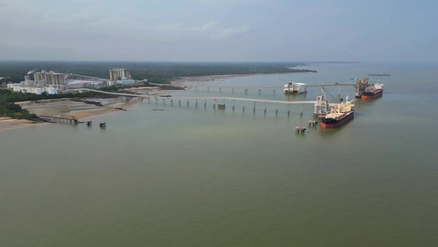 Aerial drone view of the private port in Barcarena, Para state, BR, of an industry that processes kaolin and ships globally.