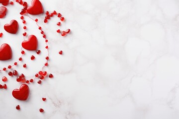 Decorative red hearts and red beads forming elegant patterns on a white marble surface.