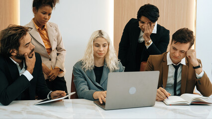 Diverse office worker employee with colleges feels tired and frustrated due to difficult problem they're facing in workspace. Overwhelming task and hardship in ornamented office workplace.
