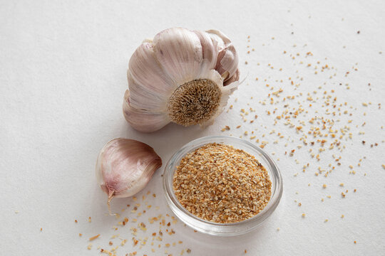 Fresh and dried garlic powder in a small dish