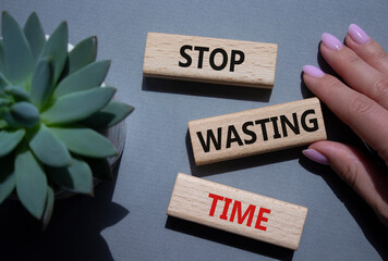 Stop Wasting Time symbol. Wooden blocks with words Stop Wasting Time. Beautiful grey background....