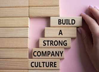 Company culture symbol. Wooden blocks with words Build a strong company culture. Beautiful pink...