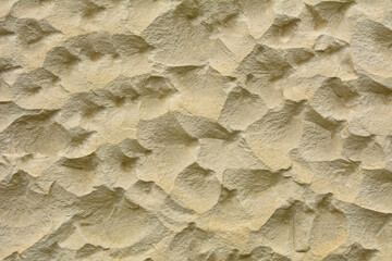 Beige stone wall with wavy surface