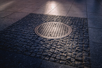 Historic manhole cover used by the insurgents during the Warsaw Uprising on Nowy Swiat Street,...