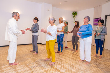 Qi gong instructor and women closing eyes and breathing