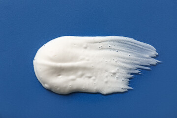Smear of shaving foam on blue background