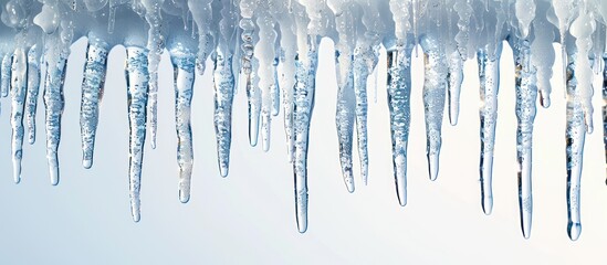 A cluster of icicles hangs precariously from the side of a building, forming delicate frozen spikes.