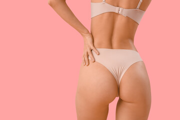 Beautiful young woman in stylish beige underwear on pink background, back view