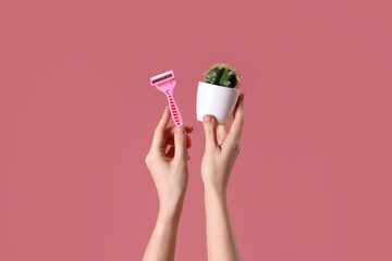 Female hands with razor and cactus on pink background - obrazy, fototapety, plakaty