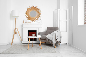 Interior of living room with golden mirror, fireplace and armchair