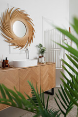 Interior of bathroom with golden mirror, drawers and sink