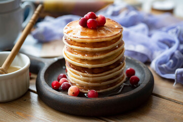 Vanilla pancakes with honey for breakfast on a wooden background. Close-up