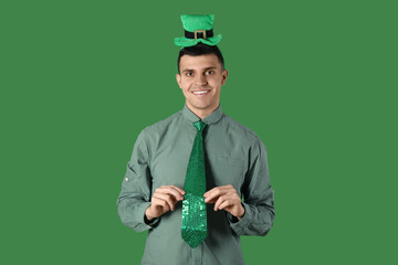 Happy young man on green background. St. Patrick's Day